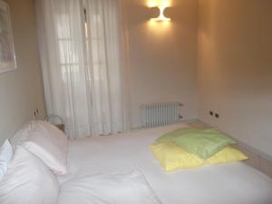 a white room with a bed and a window at Casa Vacanza Piazza in Orta San Giulio