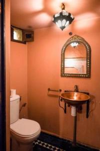 uma casa de banho com um WC, um lavatório e um espelho. em Riad Malak em Fez