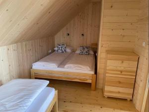 a room with two beds in a wooden cabin at Na starej drodze in Ciche