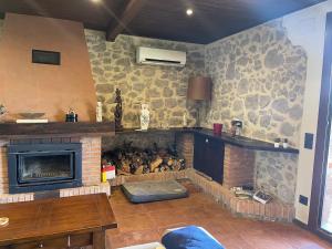 a living room with a fireplace with a stone wall at Casa Calvés in Aviá