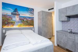 a bedroom with a bed and a painting on the wall at Arbio I Urbanstay Serviced Studios & Apartments in Graz +121 photos
