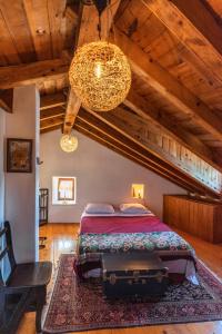 een slaapkamer met een bed, een stoel en een kroonluchter bij Charming Bohemian house in Perast in Perast
