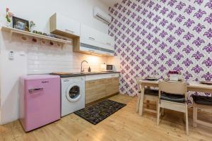 eine Küche mit einer rosa Waschmaschine und einem Tisch in der Unterkunft Elegant Coziness in Budapest
