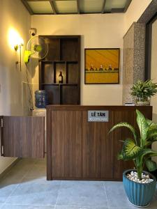 a reception desk in a lobby with a potted plant at Hotel Home in Ho Chi Minh City