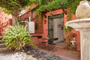 a pink house with chairs and a table in front of it at DrsRome - Colosseum Loft in Rome