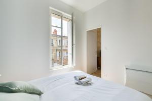 ボルドーにあるGuestReady - Calm and Modern Superb Apartmentの白いベッドルーム(ベッド1台、窓付)