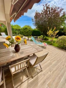 a wooden deck with chairs and a table with flowers at appartement rez de villa proche port et plages de Sanary in Sanary-sur-Mer