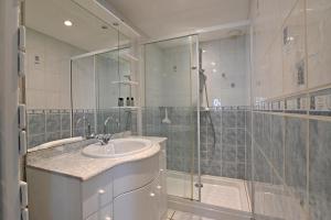 a bathroom with a sink and a glass shower at La Petite Maison Blanzy in Blanzy +7 photos