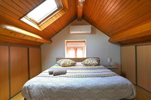 a bedroom with a large bed with a skylight at La Petite Maison Blanzy in Blanzy