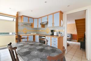 a kitchen and dining room with a table and chairs at La Petite Maison Blanzy in Blanzy