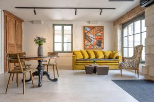 uma sala de estar com um sofá amarelo e uma mesa em Hôtel Saint Nicolas em La Rochelle