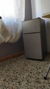 frigorifero bianco in una stanza con un piano di Affittacamere Da Priscilla a Porto Torres