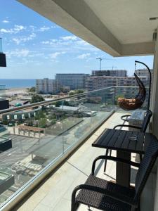 d'un balcon avec une table et des chaises et une vue sur l'océan. dans l'établissement Apartament Miramare Mamaia Nord, à Mamaia Nord – Năvodari