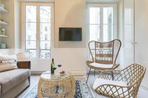 a living room with a couch and chairs and a tv at GuestReady - Lovely flat in Central Paris near Notre-Dame in Paris