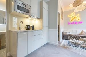 a kitchen with white cabinets and a couch at GuestReady - Lovely flat in Central Paris near Notre-Dame in Paris