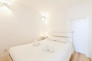 a bedroom with a white bed with white pillows at GuestReady - Oporto Sunset Blue Balcony in Porto