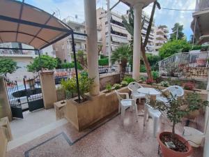 eine Terrasse mit einem Tisch, Stühlen und Bäumen in der Unterkunft Casa Oliver in Athen