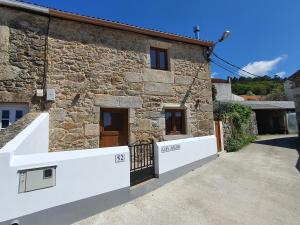 a stone house with a gate in front of it at Casa Jalecha in Muxia