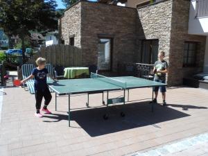 dos niños jugando ping pong en una mesa de ping pong en Linserhof Ferienappartements, en Sölden