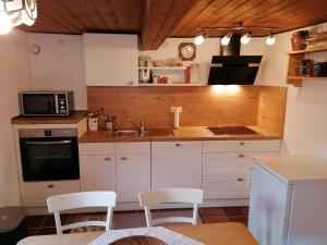 ジークスドルフにあるFerienhaus Villa klein Venedigの白いキャビネットとシンクと電子レンジを備えたキッチン