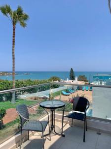 a table and chairs on a balcony with a view of the ocean at Saradari Beach Hotel - Adults Only in Hersonissos