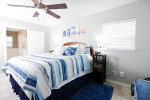 a bedroom with a bed and a ceiling fan at SUNNY DAZE Walk to Beach 2 Decks Pet Friendly Has a Mini Bar in Galveston +19 photos