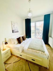 a bedroom with a large bed with blue curtains at 4 llullat - City Center Apartment in Pristina +4 photos