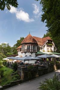ein Gebäude mit Tischen und Sonnenschirmen davor in der Unterkunft Schlossrestaurant Neuschwanstein in Hohenschwangau