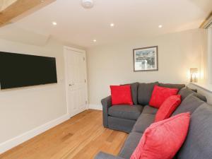 uma sala de estar com um sofá cinzento e uma televisão de ecrã plano em Roman Lodge em Weymouth