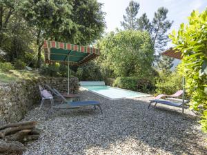 - Piscina con 2 sillas y sombrilla en Beautiful villa in Les Salelles with private pool, en Sallelles