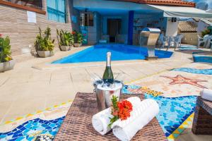 una botella de vino en una mesa junto a una piscina en Terra Brasil - Rede Soberano, en Porto Seguro