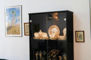 a black cabinet with dishes and other items on it at Artsy Ferhadija Studio Apartment in Sarajevo