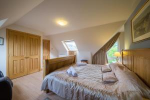 a bedroom with a large bed with two pillows on it at Errichel House and Cottages in Aberfeldy