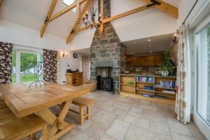 a kitchen with a wooden table and a stone fireplace at Errichel House and Cottages in Aberfeldy