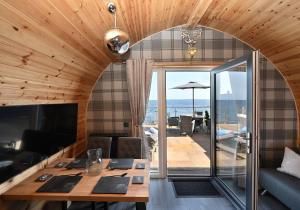 a dining room with a table and a view of the ocean at Pod 1, Sinclair bay lodges in Keiss