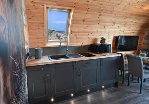 a kitchen with a counter with a sink and a window at Pod 1, Sinclair bay lodges in Keiss