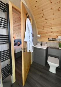 a bathroom with a bed and a toilet and a sink at Pod 1, Sinclair bay lodges in Keiss