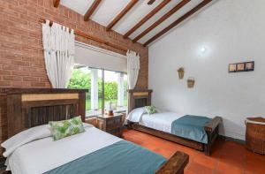 a bedroom with two beds and a window at Casa Campestre La Habana in Armenia +78 photos
