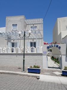 a white building with a street light in front of it at Dilino in Kamari
