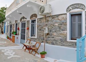 a building with a table and chairs outside of it at Casa calda - Άνετο διαμέρισμα στο Ξυλοκερατίδι Αμοργού in Katapola