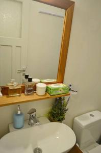 a bathroom with a sink and a mirror and a toilet at Casa calda - Άνετο διαμέρισμα στο Ξυλοκερατίδι Αμοργού in Katapola