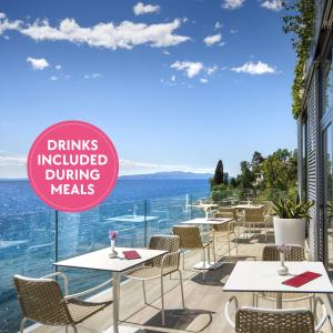 a restaurant with tables and chairs with a view of the ocean at Hotel Istra - Liburnia in Opatija