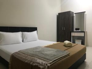um quarto com uma cama com um cobertor em Ilham Bonda Homestay em Cukai