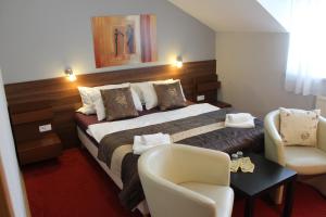 a hotel room with a bed and two chairs at Penzión Hellene in Piešťany +33 photos