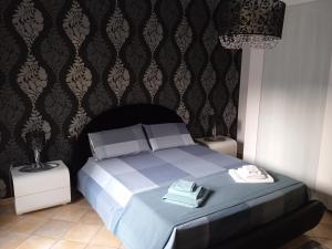 a bedroom with a bed with two tables and a chandelier at GRETA'S HOUSE in Comitini