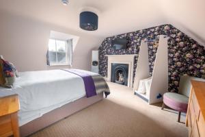 a bedroom with a bed and a fireplace at The Cottage, The Loch Ness Cottage Collection in Inverness