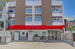 an apartment building with a red awning at OYO 869 Jnv Dream Hotel in Zambales
