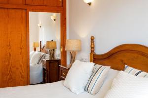 1 dormitorio con cama y espejo grande en Sa Tronita Beach House, en Cala Santanyi
