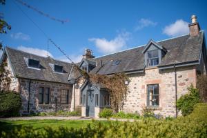 an old stone house with a gray roof at The Cottage, The Loch Ness Cottage Collection in Inverness