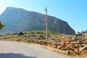 a dirt road with a mountain in the background at Ai piedi di Cofano in Custonaci